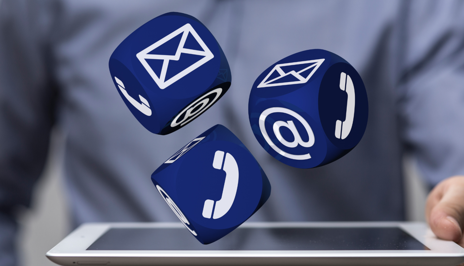 vīrietis tur rokā planšeti, no tās "lido ārā" trīs spēļu kubi ar saziņu ikonām