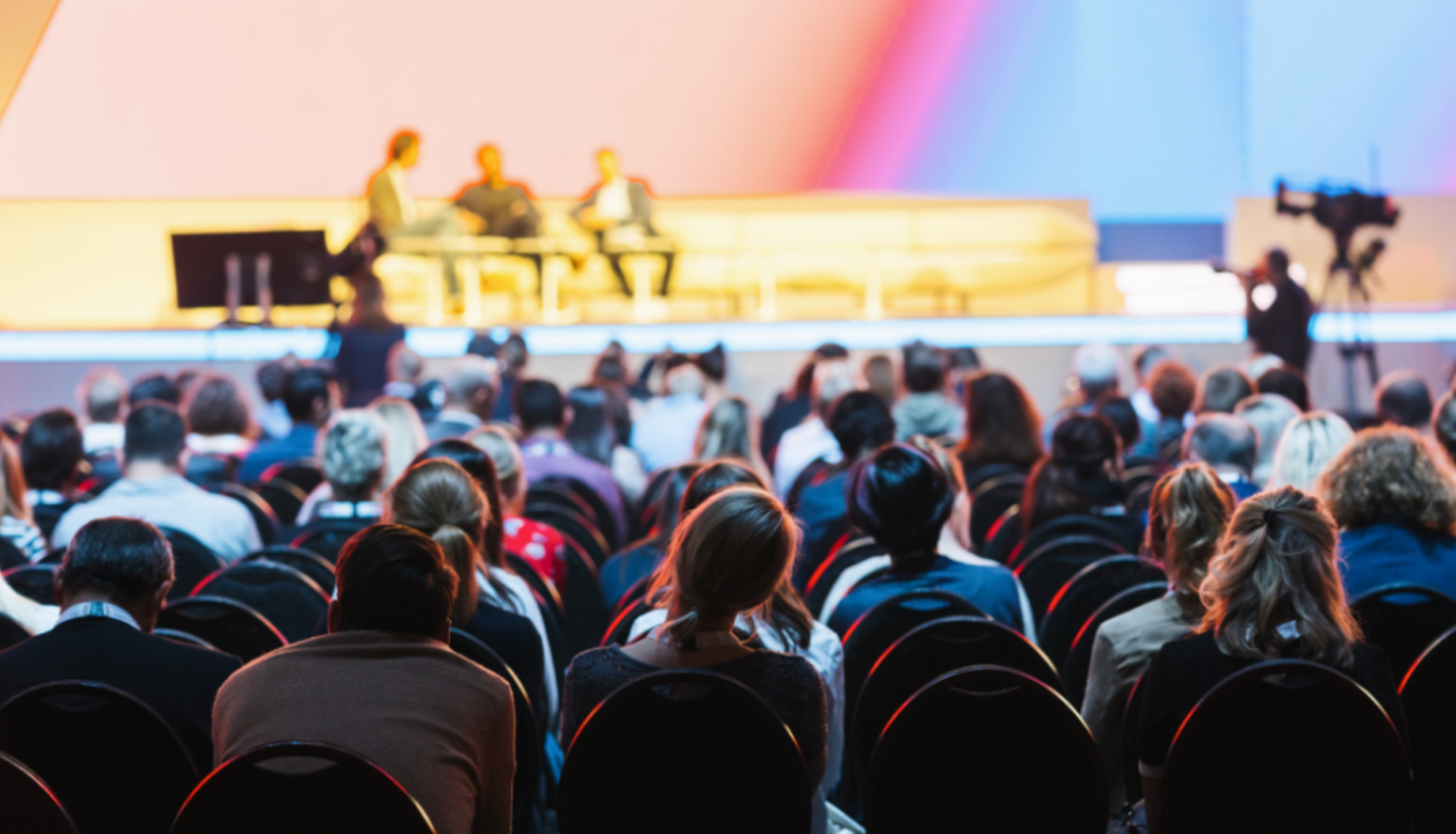 Cilvēki sēž auditorijā