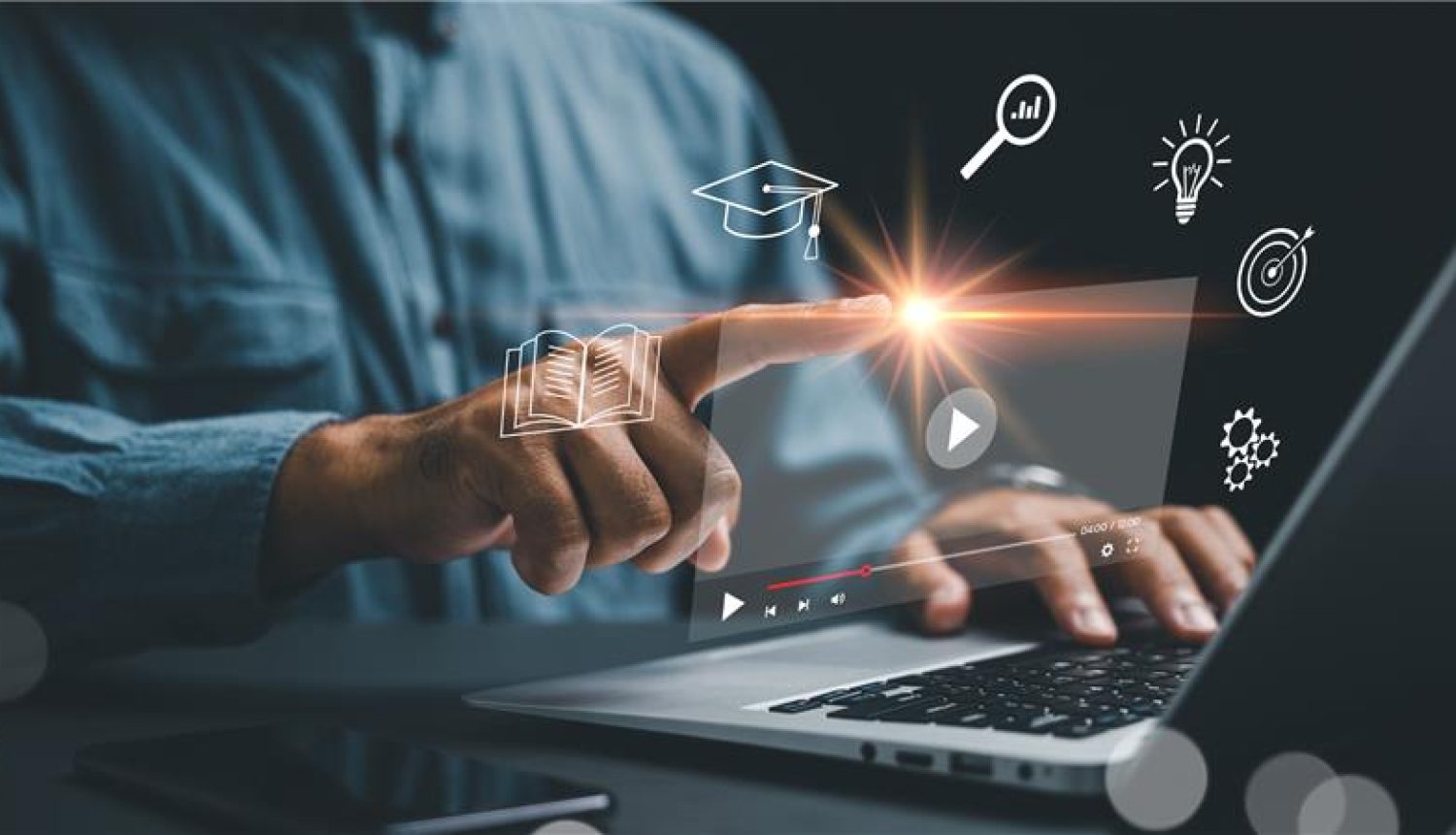 Erasmus+ ziņa; attēlā vīrietis sēž pie atvērta portatīvā datora, priekšplānā ir dažādas digitālo rīku ikonas, kuras viņš mēģina nospiest ar pirkstu