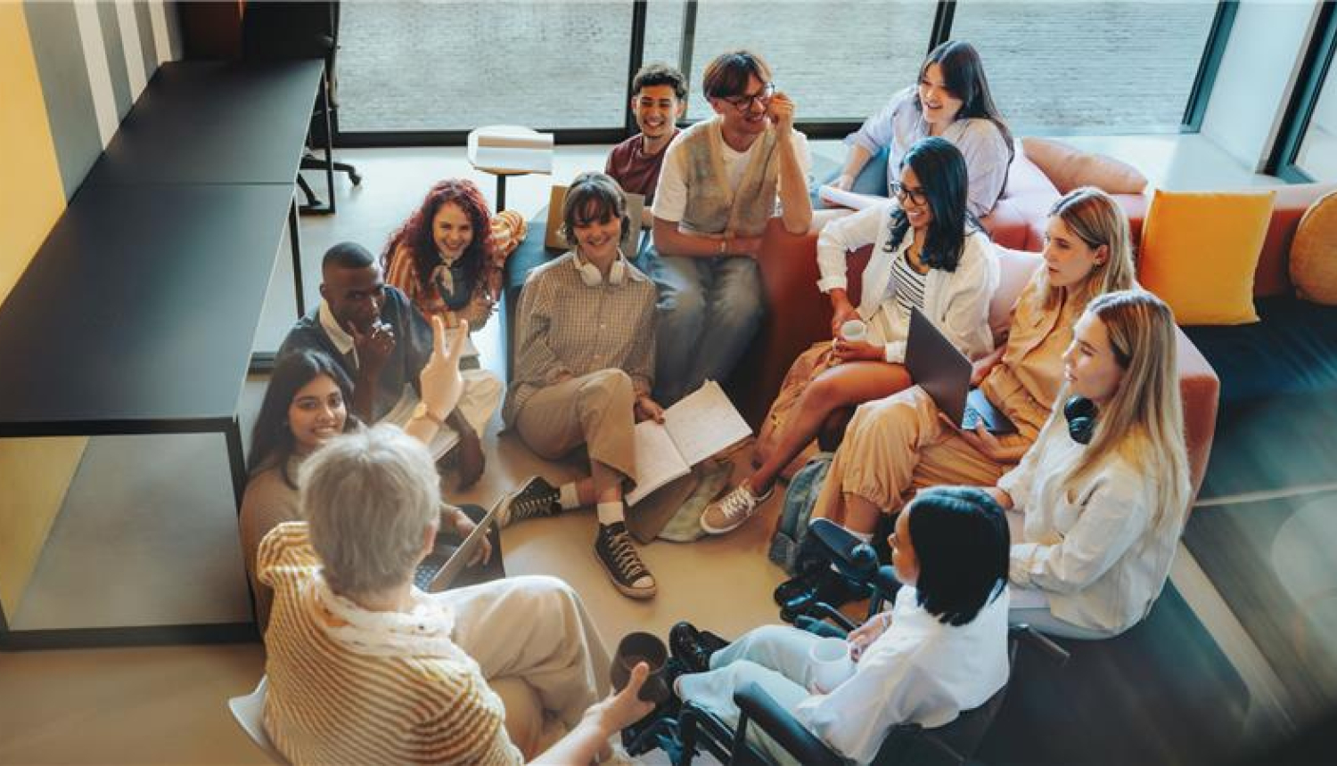 vairāki studenti sēž aplī un kaut ko apsrpeiž