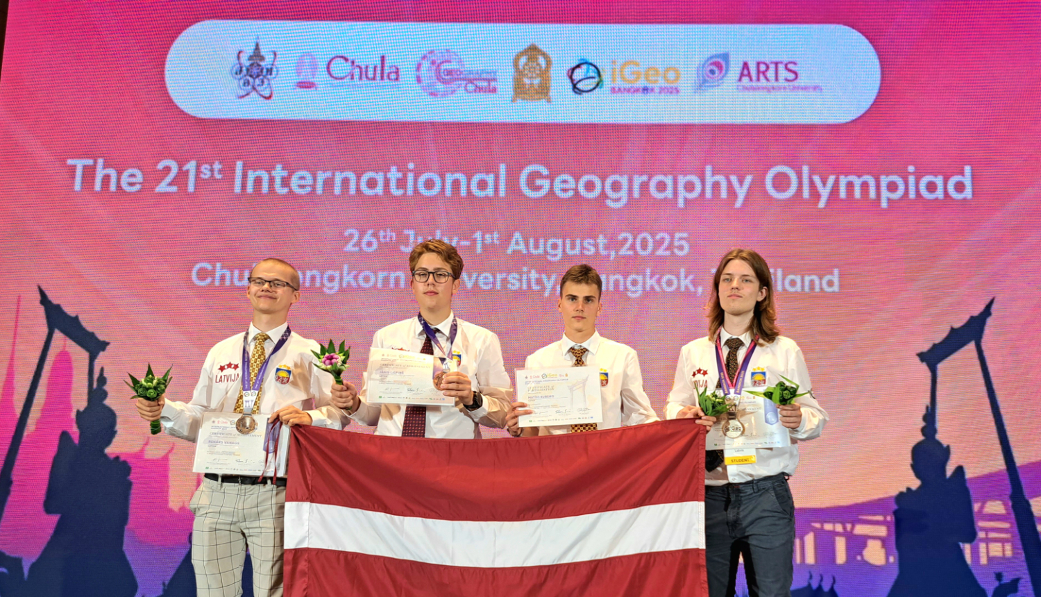 Latvijas komanda ar medaļām un LV karogu Ģeogrāfijas olimpiādē