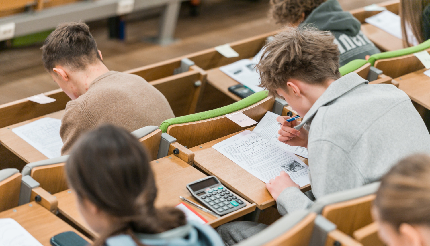 studenti sez auditorijā, pieraksta materiālu