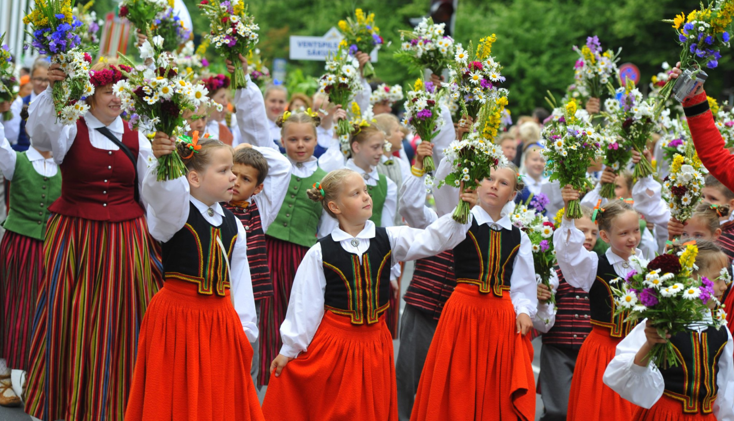 Bērni taututērpos ar ziediem rokās