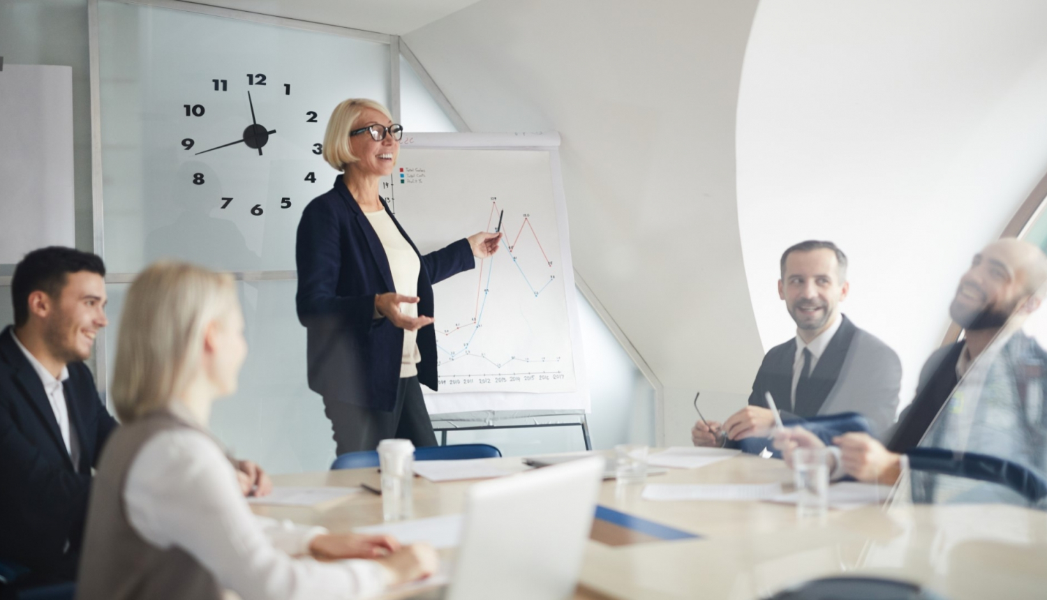 sieviete prezente kolegiem pie tafeles