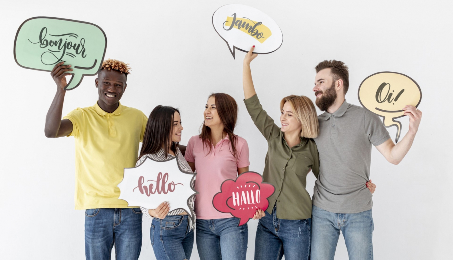 dažādu rasu jaunieši stāv ar domu mākoņiem rokās, kur rakstīti dažādi vārdi dažādās valodās