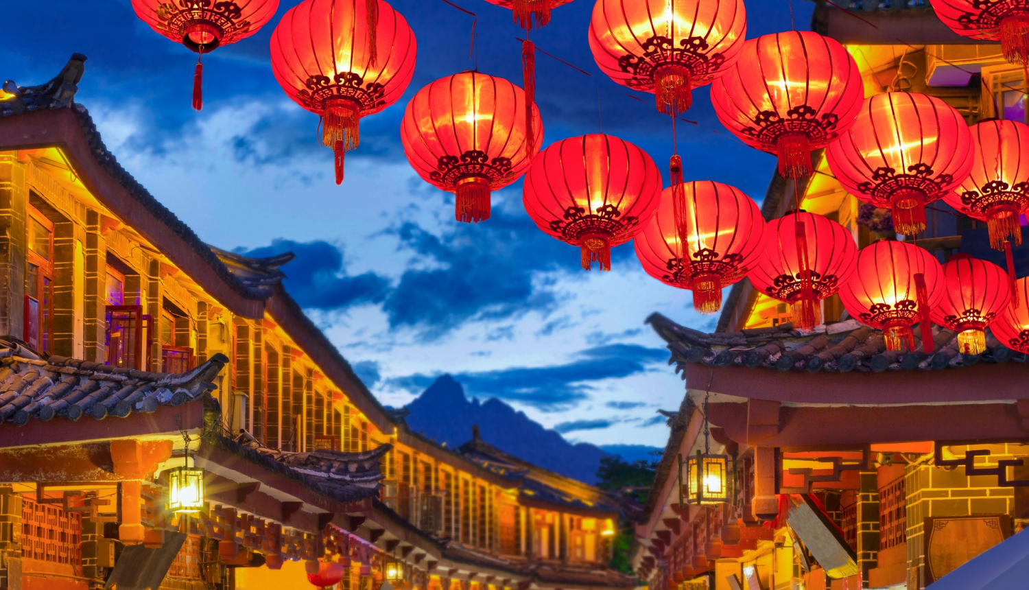 Ķīnas pilsētas ielas ainava ar laternām un kalniem fonā