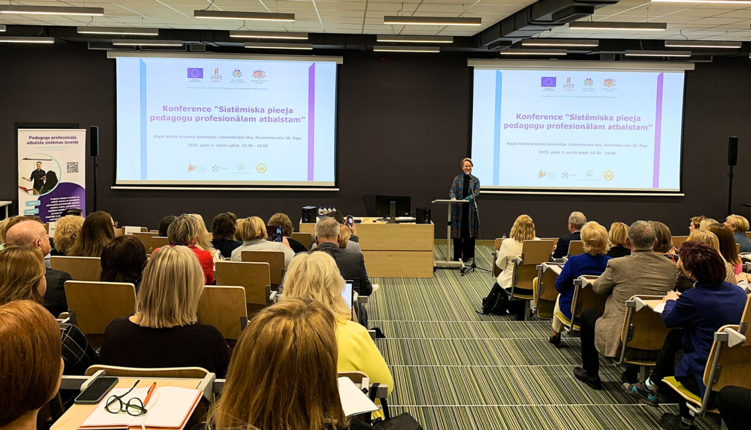 Cilvēku grupa sēž un klausās semināru