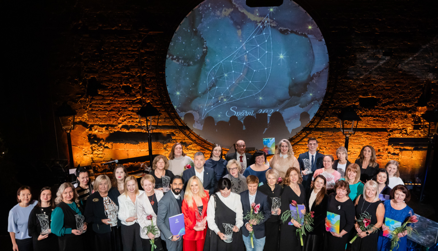 Cilvēki pozē pasākumā