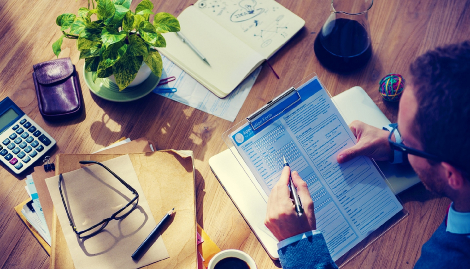 Vīrietis pilda formu uz darba galda