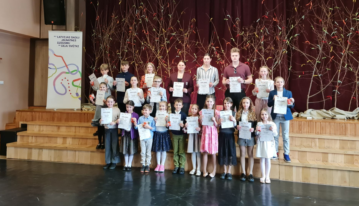 Skolēnu runas konkursa dalībnieki 2025 stāv ar diplomiem 