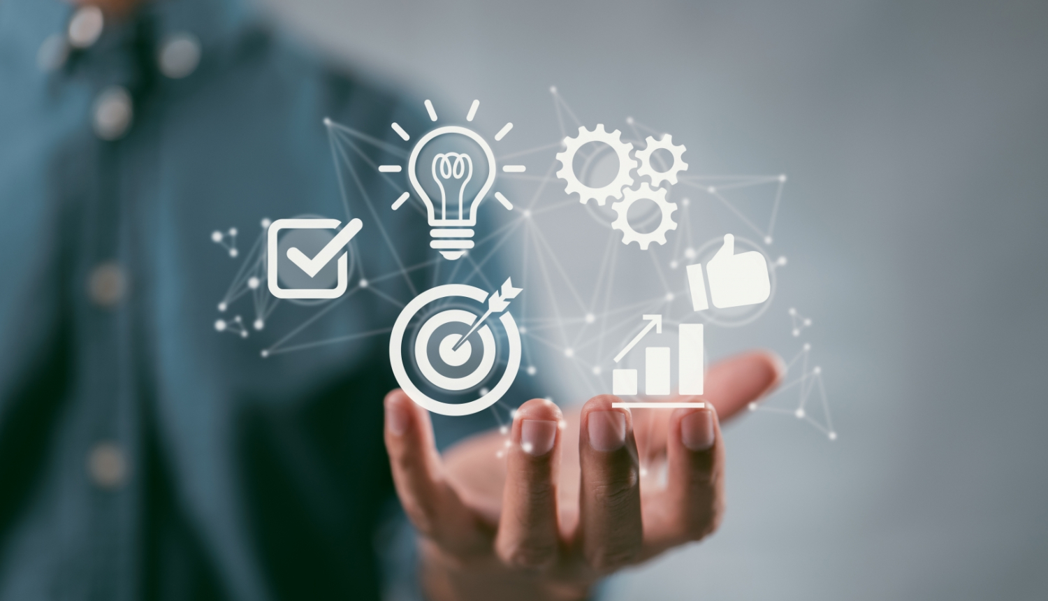 Vīrietis, nav redzama galva, kreklā, uz rokas tur dažādas ikonas