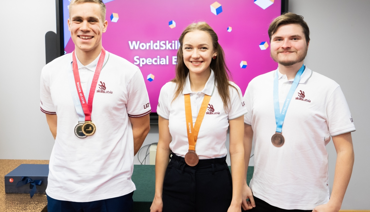 WorldSkills 2022 trīs laureāti stāv ar medaļām