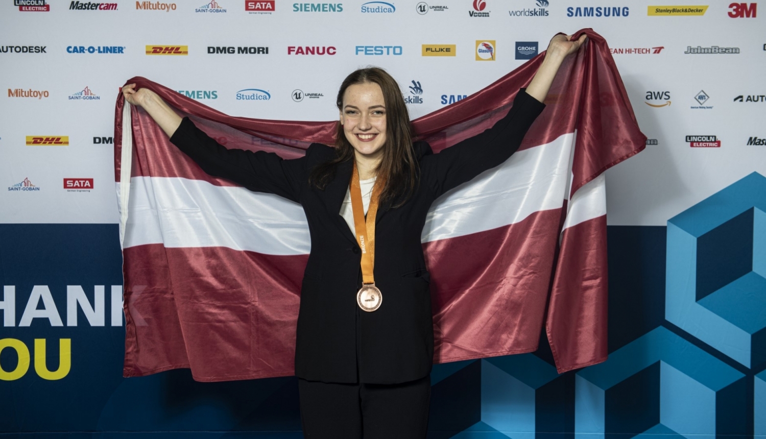WorldSkills 2022 bronzas medaļas ieguvēja Kitija Kozule ar Latvijas karogu Stokholmā